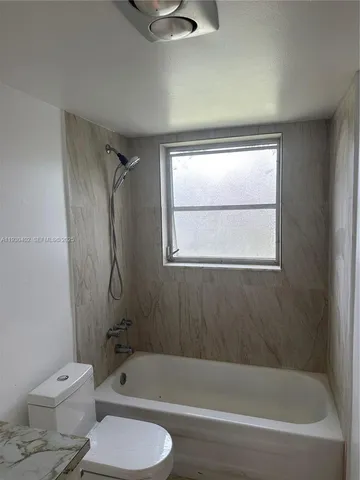 a white bath tub sitting next to a toilet