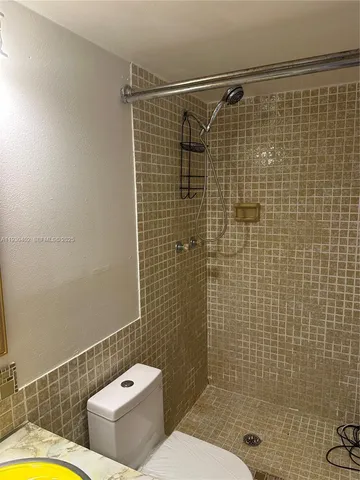 a bathroom with a shower a toilet and a shower
