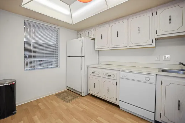 a kitchen with white cabinets and white appliances