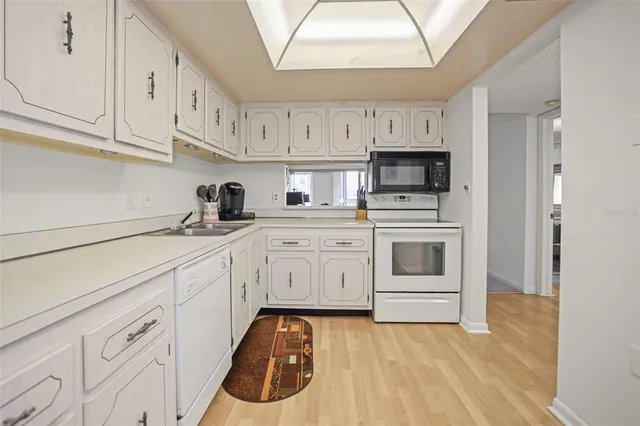 a kitchen with white cabinets and white appliances