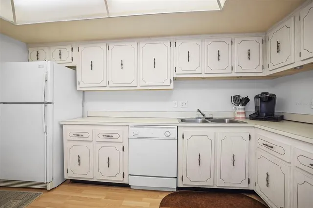 a kitchen with white cabinets and white appliances