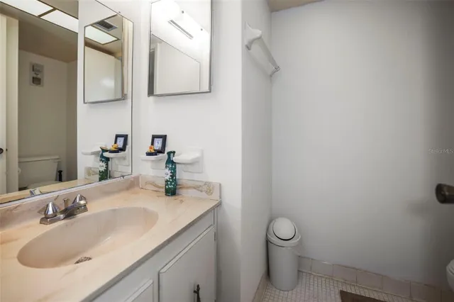 a bathroom with a granite countertop sink a toilet and a mirror