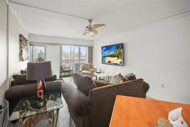 a living room with furniture ceiling fan and a window