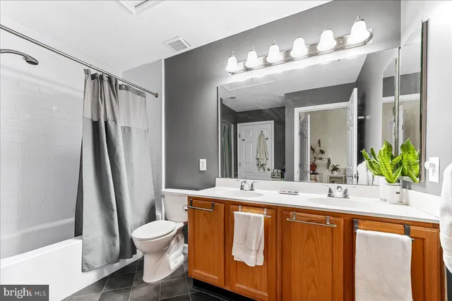 a bedroom with a bed wooden floor and a potted plant