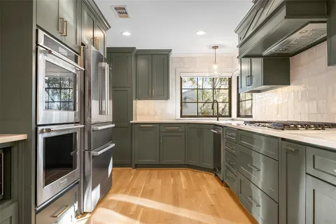 a kitchen with stainless steel appliances granite countertop a refrigerator and a stove