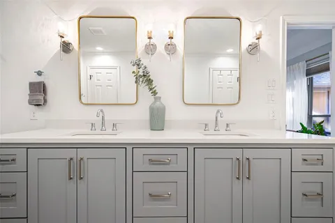 a bathroom with a double vanity sink and mirror