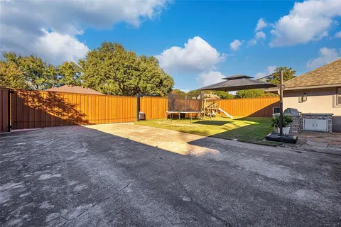 a view of a backyard with wooden fence