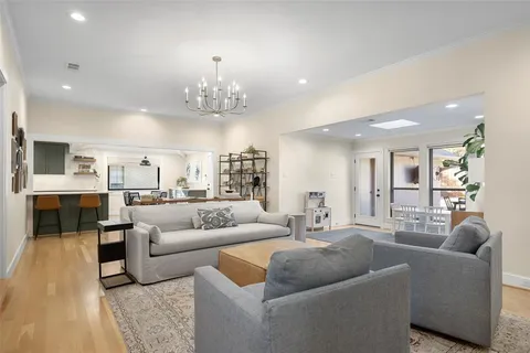 a living room with furniture and a chandelier
