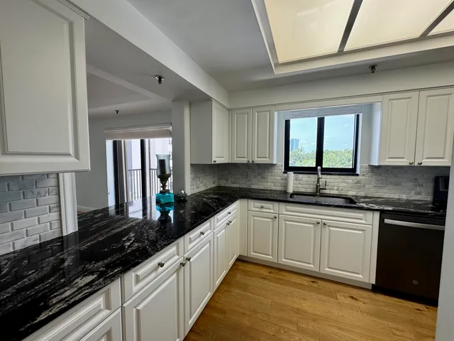 a kitchen with granite countertop a sink stainless steel appliances and cabinets