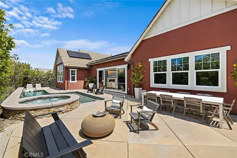 a view of a house with backyard and sitting area