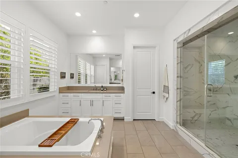 a large bathroom with a tub a sink shower and a mirror