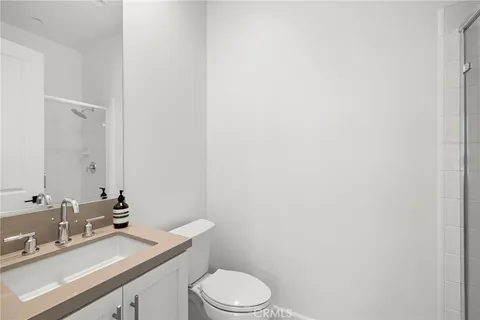 a bathroom with a granite countertop sink mirror vanity and toilet