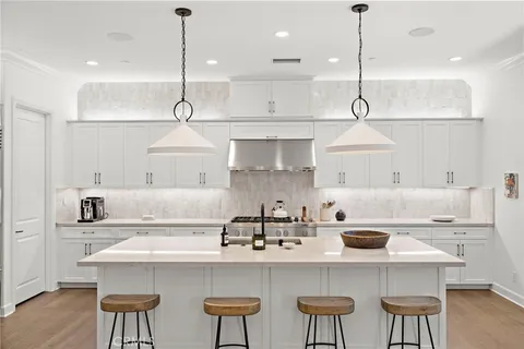 a kitchen with a white cabinets and chairs
