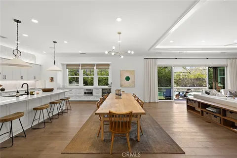 a large dining hall with stainless steel appliances granite countertop table chairs and a large window