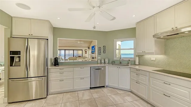 a kitchen with white cabinets stainless steel appliances and a window