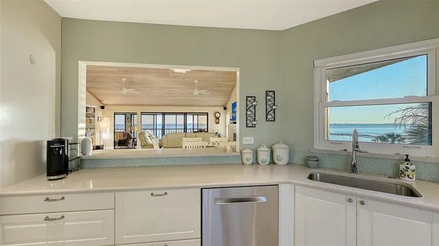 a kitchen with counter top space sink and living room