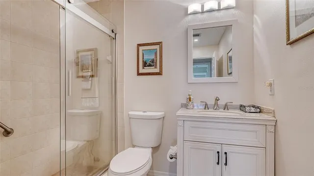 a bathroom with a toilet sink vanity and mirror