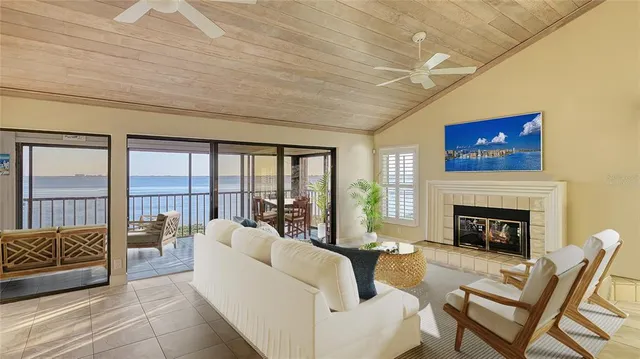 a living room with furniture a fireplace and a floor to ceiling window