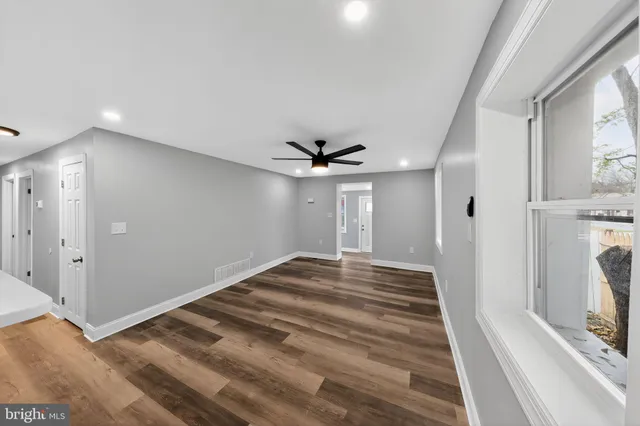 a view of a livingroom with wooden floor and a ceiling fan