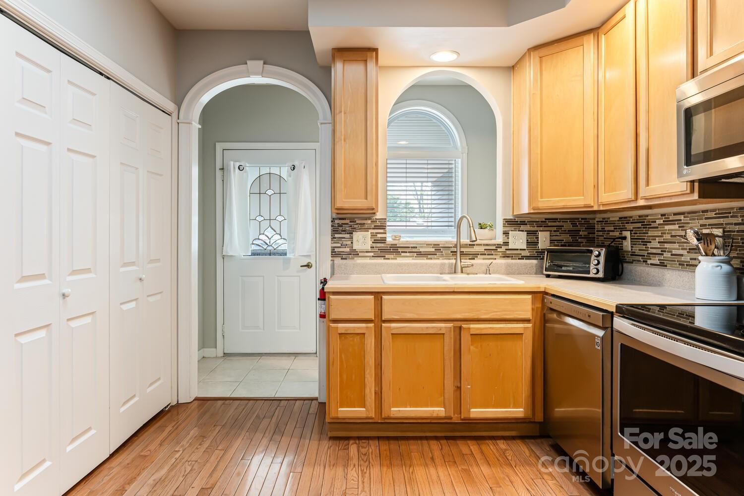 121 Shadowbrook Drive Asheville, NC 28805 - Photo 9 of 32 a kitchen with stainless steel appliances granite countertop a stove a sink dishwasher and white cabinets with wooden floor
