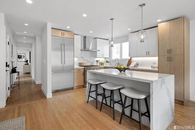 a kitchen with kitchen island white cabinets and stainless steel appliances