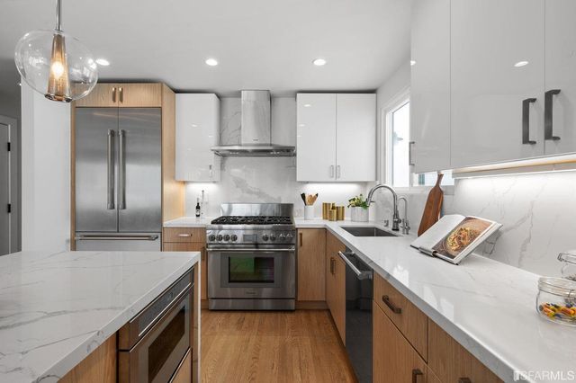 a kitchen with stainless steel appliances granite countertop a stove a sink dishwasher and a refrigerator