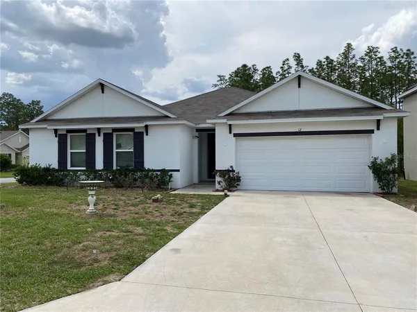 a front view of a house with yard garage and outdoor seating