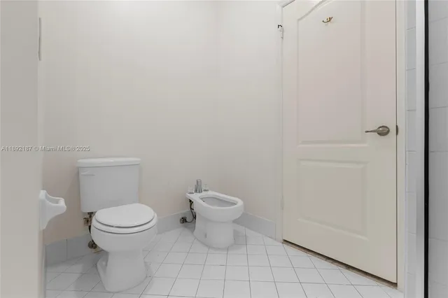 a white toilet sitting next to a white cabinet