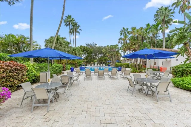 a view of a patio with a table and chairs under an umbrella