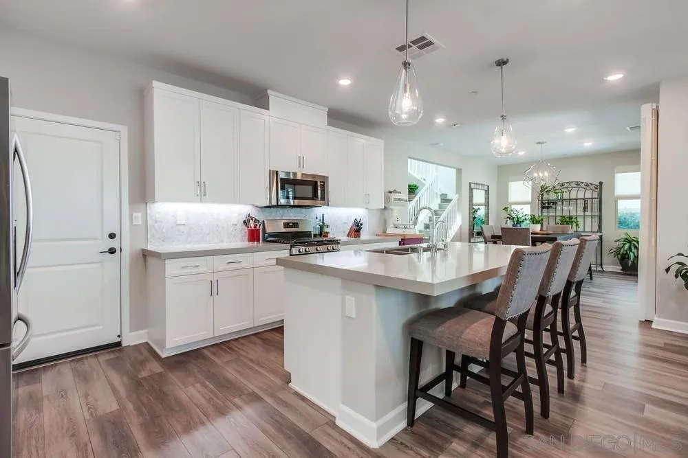 1933 Pascal Court Escondido, CA 92026 - Photo 11 of 52 a kitchen with kitchen island granite countertop a sink cabinets and wooden floor