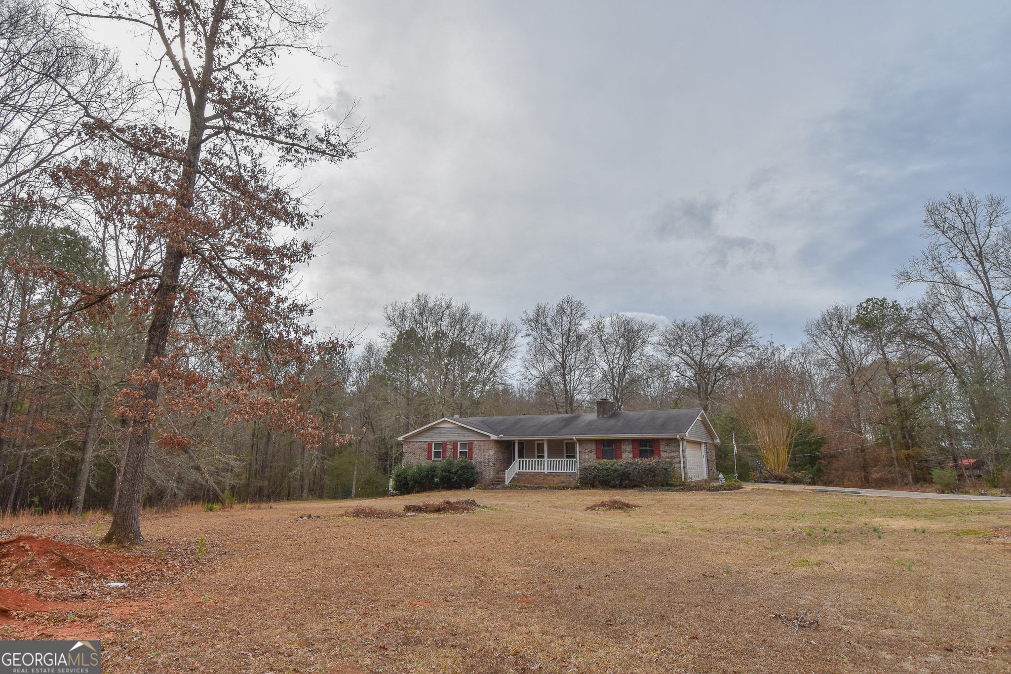 a front view of a house with a yard and large trees