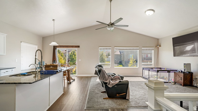 6062 Spring Street Stansbury Park, UT 84074 - Photo 8 of 36 Open-concept living area featuring a vaulted ceiling and LVP flooring in traffic areas.
