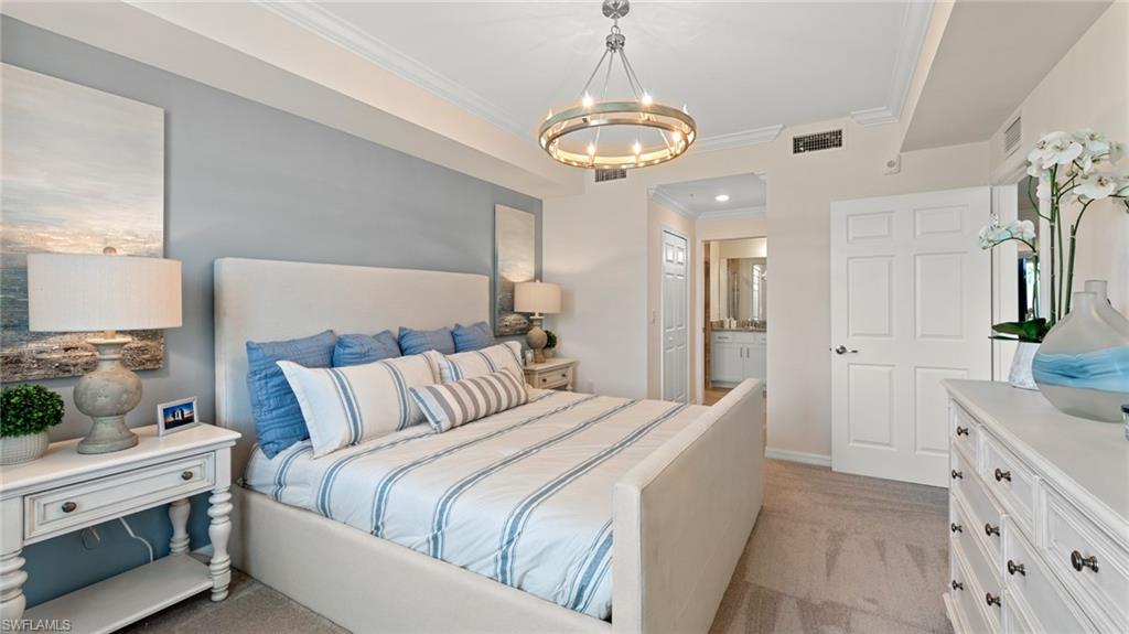 5467 Double Eagle Circle, Unit 3225 Ave Maria, FL 34142 - Photo 16 of 31 a bedroom with a large bed and a chandelier