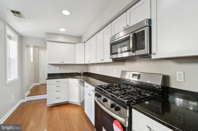 a kitchen with stainless steel appliances granite countertop a stove and a microwave