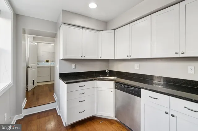 a kitchen with granite countertop white cabinets and sink