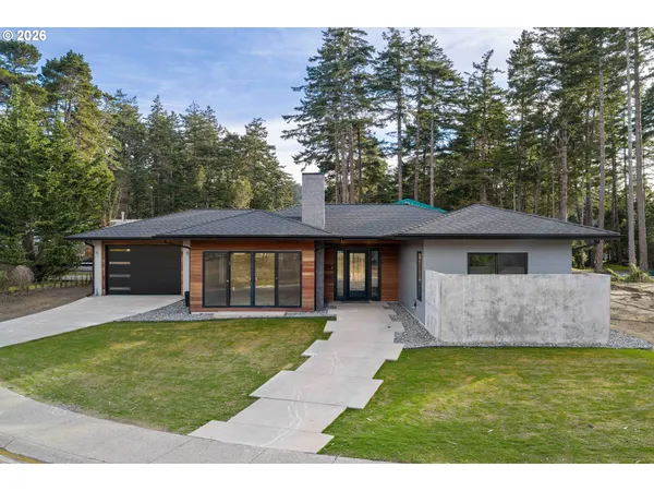 a front view of a house with a yard and trees