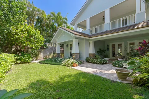 a front view of a house with a yard and potted plants