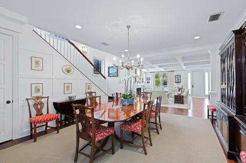 a dining room with furniture a chandelier and wooden floor