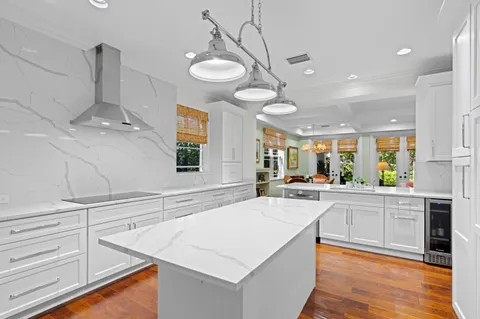 a large kitchen with kitchen island a large counter space a sink appliances and cabinets