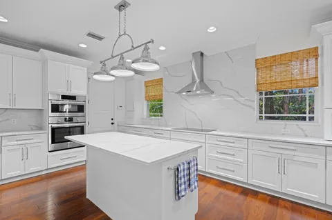 a kitchen that has a lot of cabinets in it and wooden floor
