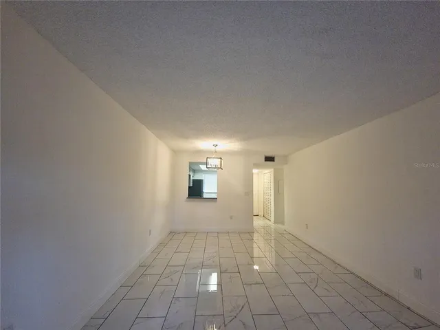 a view of a livingroom with an empty space and a window