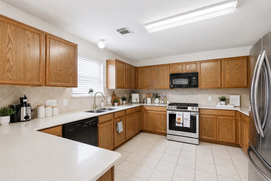 3010 Swift Brook Glen Way Spring, TX 77389 - Photo 5 of 17 a large kitchen with stainless steel appliances granite countertop a stove top oven a sink dishwasher and a refrigerator