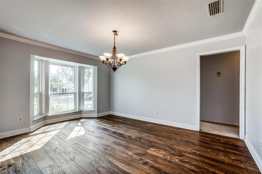 9911 Silver Creek Road Dallas, TX 75243 - Photo 10 of 28 Wood-finish flooring, bay window, crown molding, and a chandelier lighting fixture
