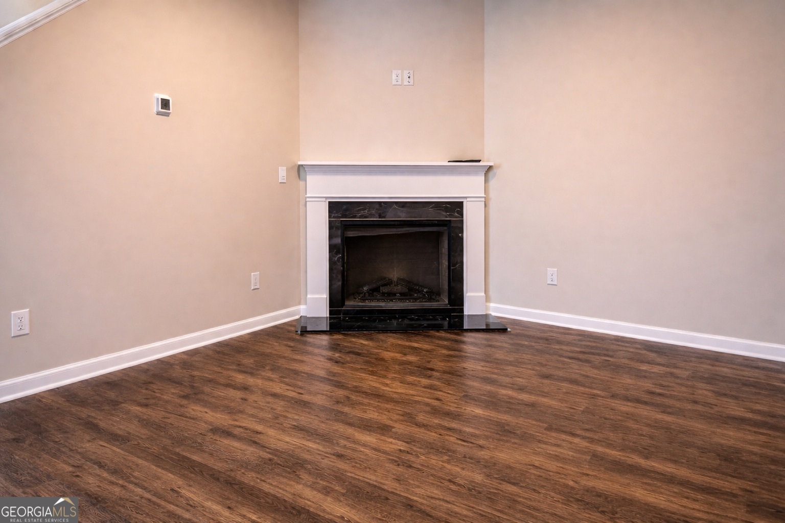 11922 Lovejoy Crossing Way Hampton, GA 30228 - Photo 4 of 15 a view of an empty room with wooden floor and a fireplace