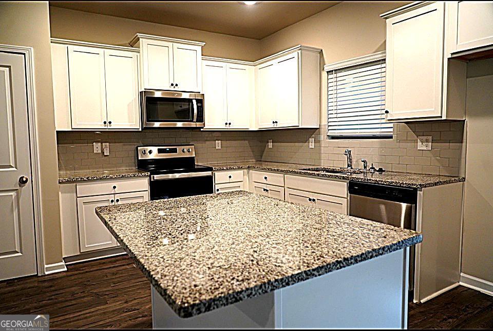 11922 Lovejoy Crossing Way Hampton, GA 30228 - Photo 5 of 15 a kitchen with a stove a sink and a microwave