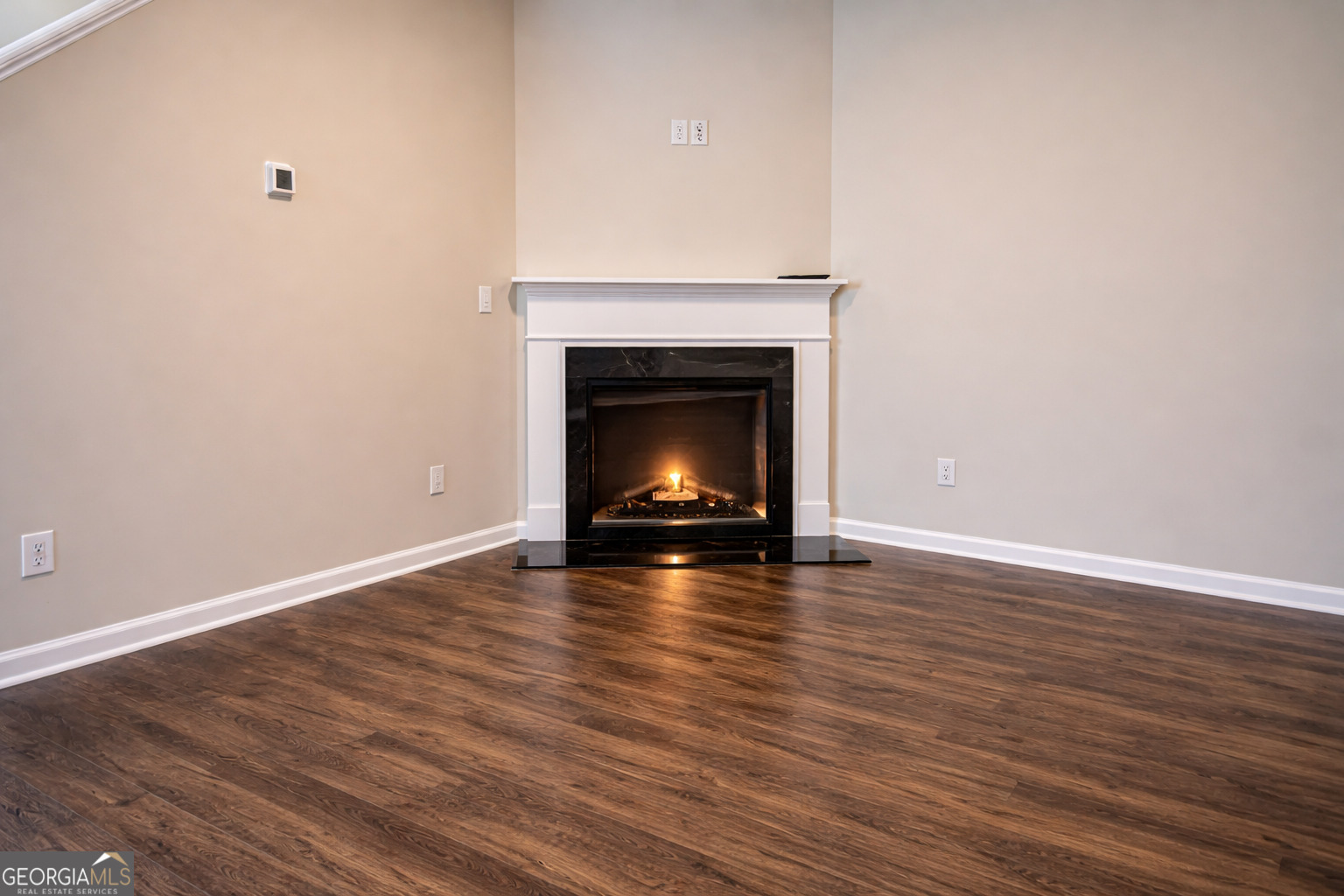 11922 Lovejoy Crossing Way Hampton, GA 30228 - Photo 6 of 15 a view of an empty room with wooden floor and fire place