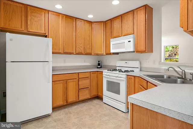 a kitchen with stainless steel appliances granite countertop a refrigerator sink stove and cabinets