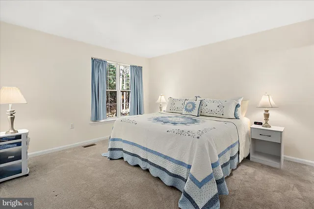 a spacious bedroom with a bed and a window