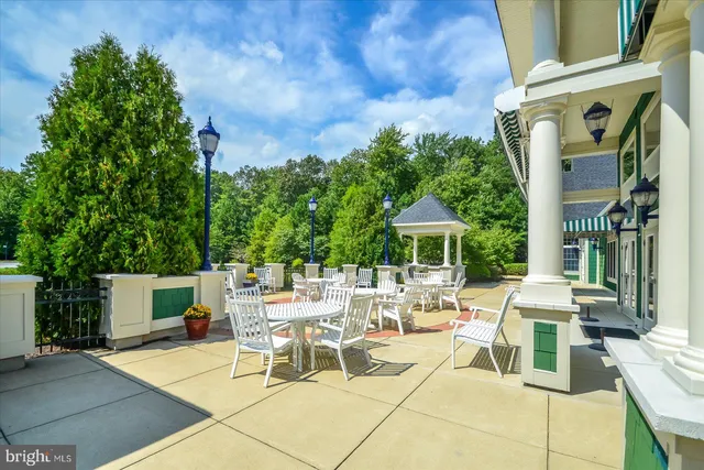 a view of a patio with a table and chairs under an umbrella with a fire pit