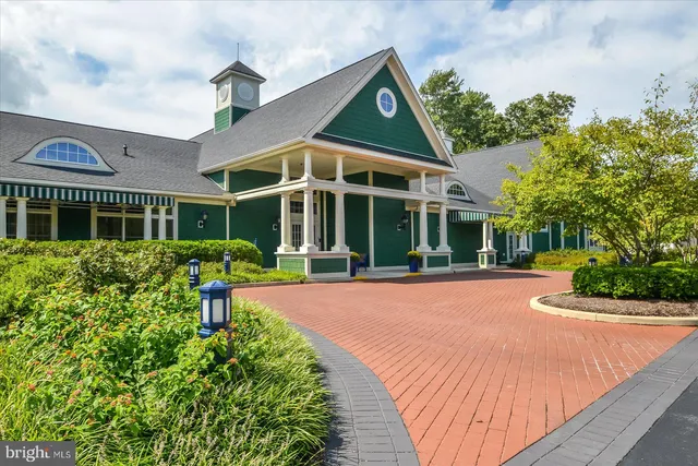 a front view of a house with yard and green space